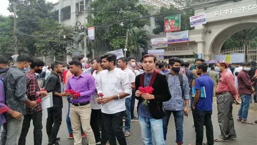 শিক্ষার্থীদের লাল গোলাপ দিয়ে বরণ করে নিচ্ছে ঢাকা কলেজ ছাত্রদল। 