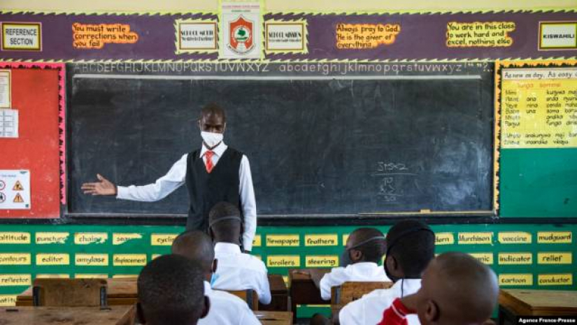 উগান্ডার কাম্পালায় স্কুল খোলার প্রথম দিনে একজন শিক্ষক ছাত্রদের স্বাগত জানাচ্ছেন