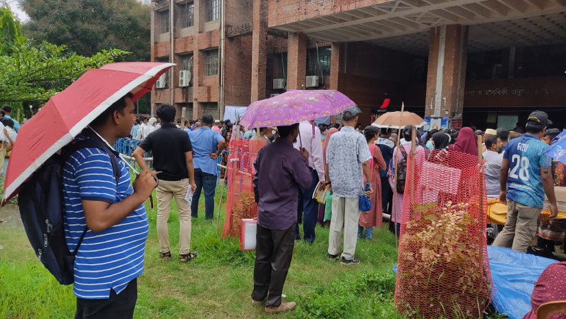 বৃষ্টি মাথায় নিয়ে পরীক্ষার হলের সামনে দাঁড়িয়ে আছেন অভিভাবকরা